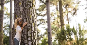 Mujer se abraza a un árbol en el bosque